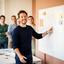 Sanne Bakker werkt met een projectteam aan een whiteboard
